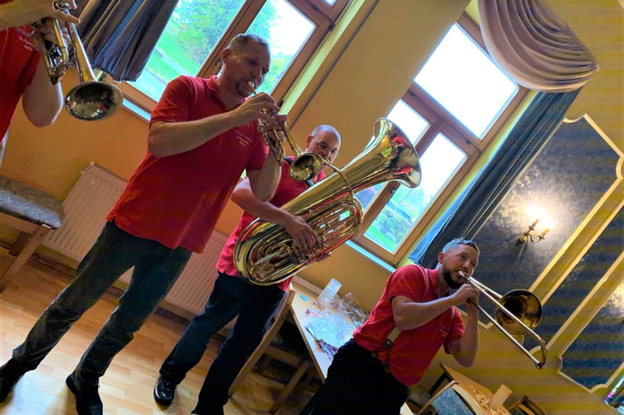 Brass-Ensemble in roten Shirts. Trompete, Posaune und Tuba im Innenraum – Blasmusik Thüringen als Kapelle für Kirmes.